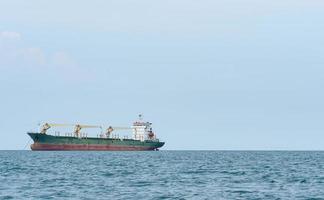 grande navio com descarga de guindaste no oceano com paisagem de céu azul, conceito de navio de carga no mar industrial foto