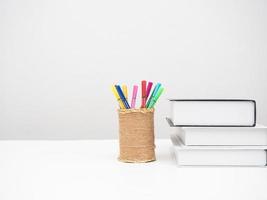 livros com caixa de cor de lápis na mesa espaço de cópia de fundo branco foto