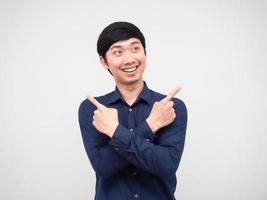 homem asiático sorrindo braço cruzado e dedo olhando para o espaço retrato fundo branco foto