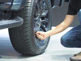 mão de homem checando roda grande de carro novo foto