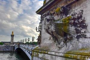 a pont alexandre iii é uma ponte em arco que atravessa o sena em paris. liga o bairro dos champs-elysées aos dos inválidos e à torre eiffel. foto