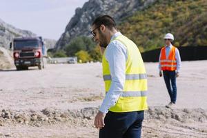 O engenheiro agrimensor está medindo o nível no canteiro de obras. topógrafos garantem medições precisas antes de realizar grandes projetos de construção. foto