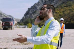 O engenheiro agrimensor está medindo o nível no canteiro de obras. topógrafos garantem medições precisas antes de realizar grandes projetos de construção. foto