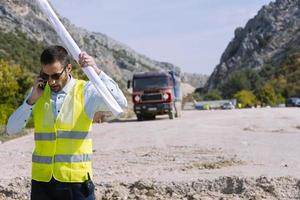 O engenheiro agrimensor está medindo o nível no canteiro de obras. topógrafos garantem medições precisas antes de realizar grandes projetos de construção. foto