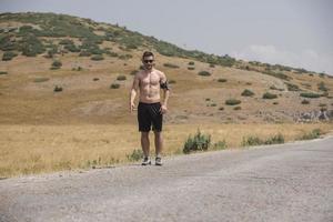 corredor de jovem correndo em uma estrada de montanha. treino de corredor em sapato de fitness. estilo de vida saudável e conceito de esporte. borrão de movimento e foco seletivo. foto