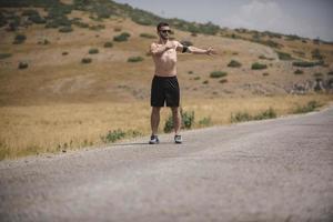 corredor de jovem correndo em uma estrada de montanha. treino de corredor em sapato de fitness. estilo de vida saudável e conceito de esporte. borrão de movimento e foco seletivo. foto