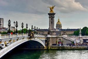 a pont alexandre iii é uma ponte em arco que atravessa o sena em paris. liga o bairro dos champs-elysées aos dos inválidos e à torre eiffel. foto