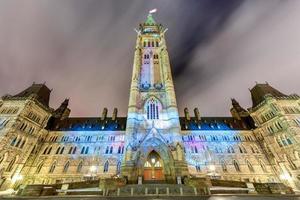 show de luzes de férias de inverno projetado à noite na casa do parlamento canadense para comemorar o 150º aniversário da confederação do canadá em ottawa, canadá. foto