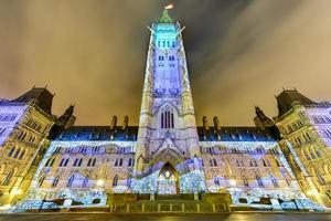 show de luzes de férias de inverno projetado à noite na casa do parlamento canadense para comemorar o 150º aniversário da confederação do canadá em ottawa, canadá. foto