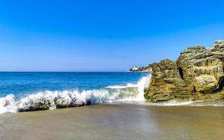 grandes ondas de surfista e rochas na praia puerto escondido méxico. foto