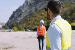 O engenheiro agrimensor está medindo o nível no canteiro de obras. topógrafos garantem medições precisas antes de realizar grandes projetos de construção. foto