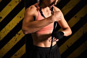 close-up de uma mulher fazendo bandagens de boxe em uma gaiola de luta foto