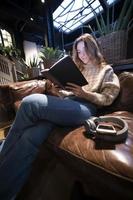 menina bonita, lendo um livro, conceitos de casa e conforto foto