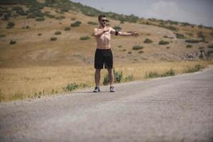 corredor de jovem correndo em uma estrada de montanha. treino de corredor em sapato de fitness. estilo de vida saudável e conceito de esporte. borrão de movimento e foco seletivo. foto