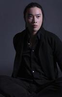 homem bonito de moda asiática posando no estúdio em fundo preto, conceito de estilo de vida de pessoas modernas foto