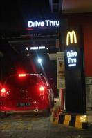 oeste de java, indonésia em julho de 2022. sinal brilhante do restaurante mcdonalds contra o céu noturno. logotipo do mcd drive thru. foto