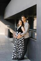 um jovem casal esperando por seu filho. o marido abraça a barriga da esposa. primeira gravidez. foto