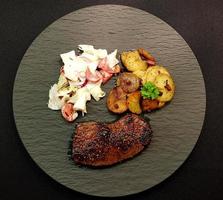 um bife recém frito da frigideira com ingredientes deliciosos foto