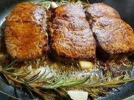 um bife recém frito da frigideira com ingredientes deliciosos foto