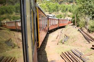 trem de brinquedo movendo-se nas encostas das montanhas, bela vista, uma montanha lateral, um vale lateral movendo-se na ferrovia para a colina, entre a floresta natural verde. trem de brinquedo de kalka para shimla na índia, trem indiano foto