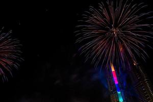 comemoração de ano novo, multidão e fogos de artifício coloridos perto do rio, tailândia foto