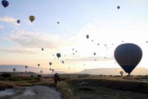 viajar para goreme, capadócia, turquia. o nascer do sol nas montanhas com muitos balões de ar quente no céu. foto