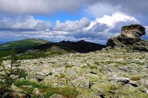 viajar para os montes urais, rússia. a vista de um pico nas montanhas, floresta e céu nublado. foto