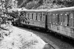 trem de brinquedo movendo-se na encosta da montanha, bela vista, uma montanha lateral, um vale lateral movendo-se na ferrovia para a colina, entre a floresta natural verde. foto