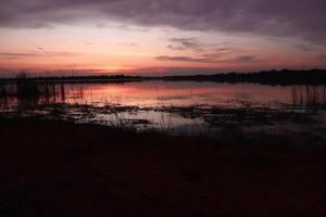 bela vista da natureza ao pôr do sol, vista do céu vermelho-laranja e rio ao pôr do sol. foto