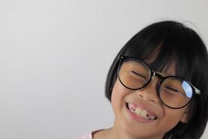 retrato de criança usando óculos em fundo branco foto