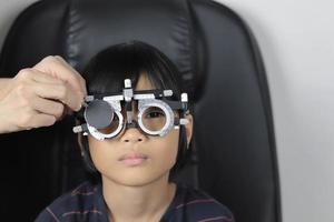 teste de olho de menina, teste de olho de criança, conceito de olho de teste, criança usando óculos, óculos de armação de teste foto