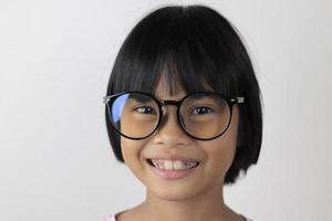 retrato de criança usando óculos em fundo branco foto