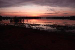 bela vista da natureza ao pôr do sol, vista do céu vermelho-laranja e rio ao pôr do sol. foto