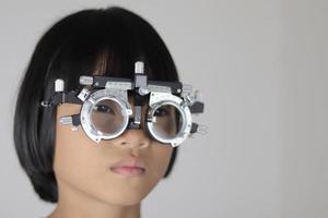 menina usando óculos de armação de teste, conceito de teste de olho foto
