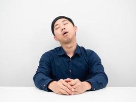 homem asiático dormindo profundamente na mesa sentindo-se tentado por trabalhar fundo branco foto