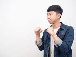 homem asiático camisa jeans gesto boxe guarda vista lateral copie o espaço foto