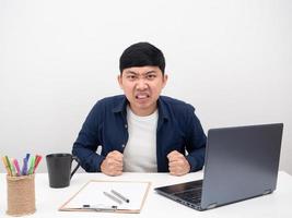 funcionário do sexo masculino sentado no local de trabalho do escritório esmagar o punho na mesa emoção com raiva foto