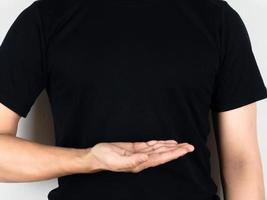 camisa preta do homem mostra a mão vazia em seu corpo fundo branco foto