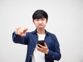 homem asiático segurando o telefone inteligente e apontando o dedo para você sentindo raiva retrato branco isolado foto