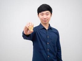 rosto feliz de homem asiático mostra bitcoin de ouro na mão fundo branco foto