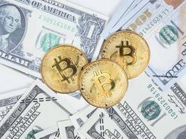 bitcoins dourados na vista superior do dólar de dinheiro foto