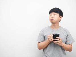 homem sonolento emoção segurando a xícara de café e olhando para o espaço da cópia foto