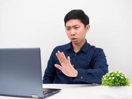 homem asiático trabalha de ponta usando laptop para explicar o trabalho on-line, sentindo-se sério foto