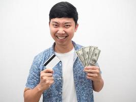homem camisa azul mostrando cartão de crédito e dinheiro dólar feliz emoção satisfazer rosto foto