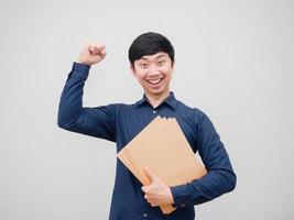 empresário segurando o envelope do documento com um sorriso feliz mostra o punho no fundo branco foto