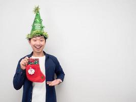 homem usando chapéu verde e segurando meia de natal sentindo feliz emoção copie o espaço foto