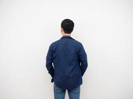 vista traseira de homem bonito em terno jeans em pé no fundo branco do estúdio foto