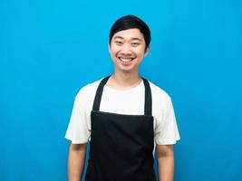 homem asiático vestindo avental sorriso feliz fundo azul foto