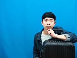 homem com gesto de bagagem pensando e olhando fundo azul do conceito de férias foto