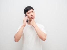 homem asiático falando com o pensamento de celular e decidir rosto sério fundo branco foto